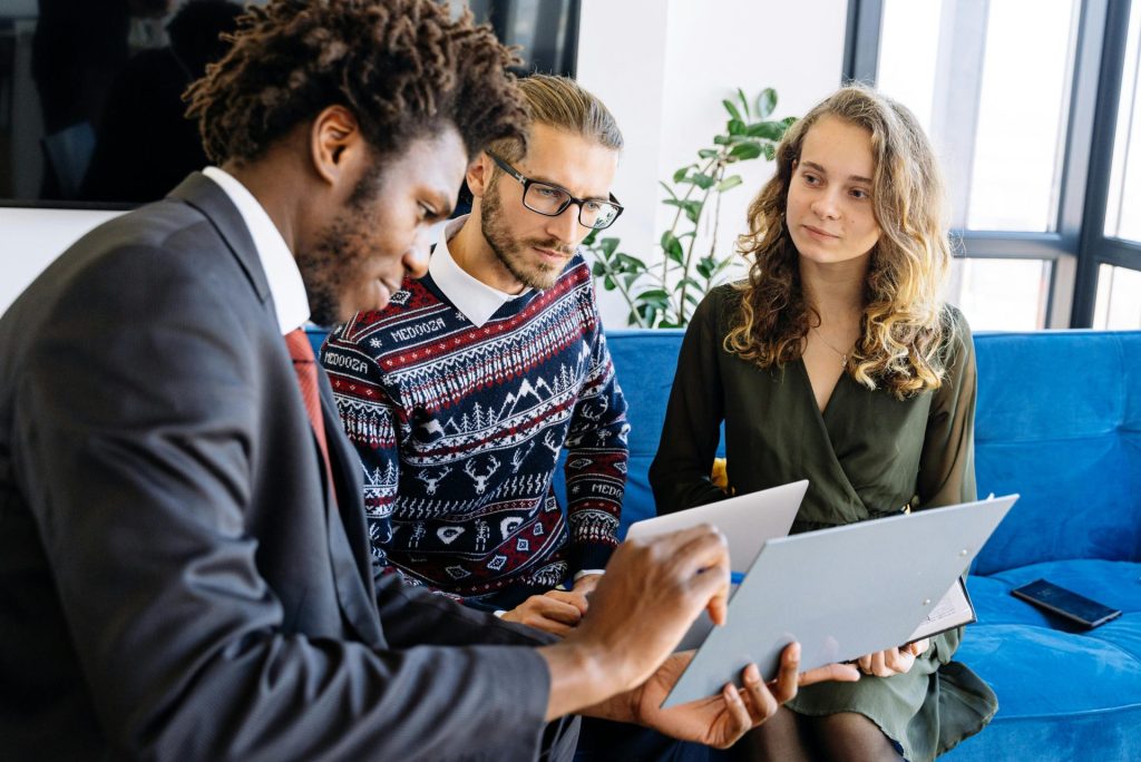 Un groupe diversifié de jeunes professionnels participent à une réunion d'affaires dans un bureau moderne.